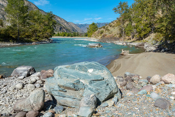 Huge boulder on the Bank of the mountain river Chuya, Argut cluster, Altai Republic