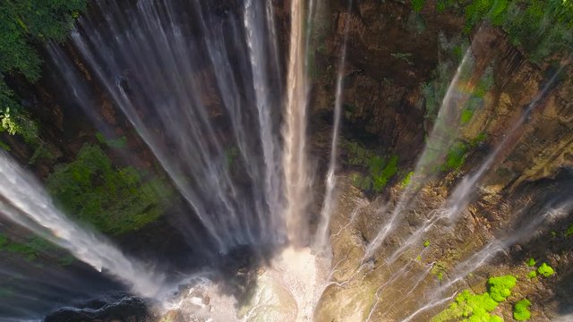 beautiful waterfall Coban Sewu in tropical forest, Java Indonesia. aerial view tumpak sewu waterfall in rainforest aerial footage