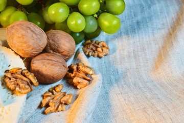 walnuts and green grapes lie on linen cloth