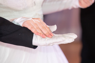 Fototapeta na wymiar Wedding theme, holding hands newlyweds White gloves