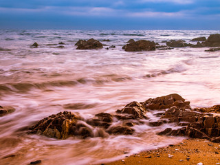 beach coastline with motion blurred water and rocks