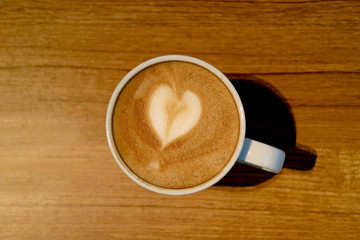 A Cup of Hot Cappuccino Coffee with Heart Shaped Latte Art Served on Wooden Table 