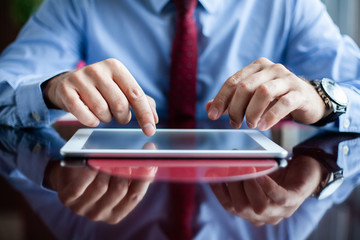 Close-up of professional businessman using modern digital tablet at his office.