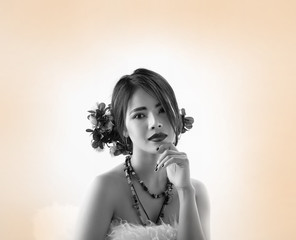 The beautyful lady with flower hair clip on her head,put finger  to touch her chin,looking with...