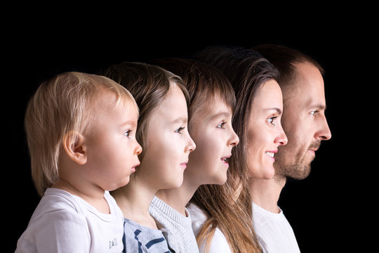 Family portrait of father, mother and three boys, profile picture of them all in a row, isolated on black background