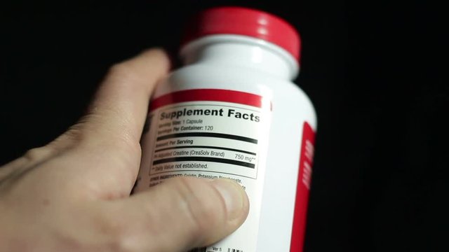 The athlete reads the food composition of sports supplements