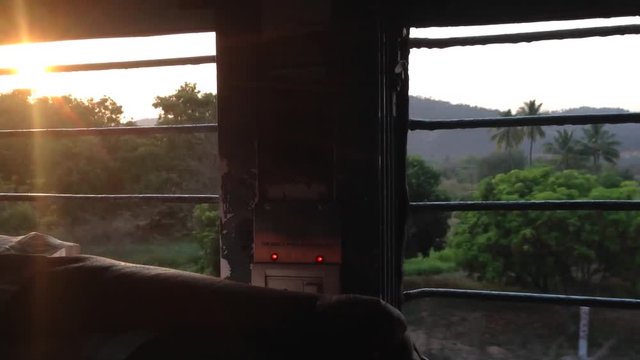Sunset: passenger journey train rides view from train man a sleep in Indian Railways, Indian trains, sleeper class, the sun's rays hit train at sunset