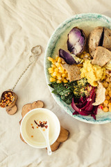 Vegan detox lunch with a purple potato, stewed spinach, and hummus with corn crackers.