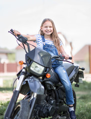 Fototapeta na wymiar little girl driving a motorcycle