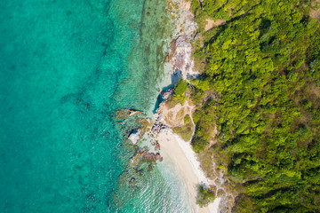 Aerial top view of ocean waves, beach and rocky coastline and beautiful forest. Beautiful nature background.