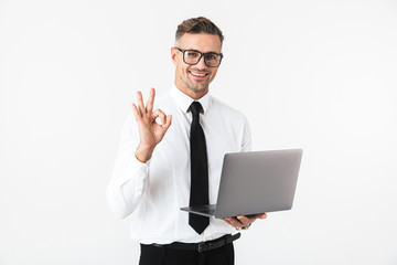 Handsome business man isolated over white wall background using laptop computer.