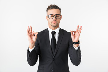 Handsome business man isolated over white wall background meditate.
