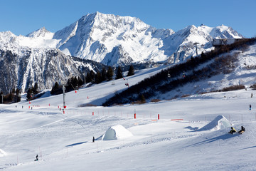 Fototapeta na wymiar Slope on the skiing resort in Alps, France. Sunny winter day. Winter vacation