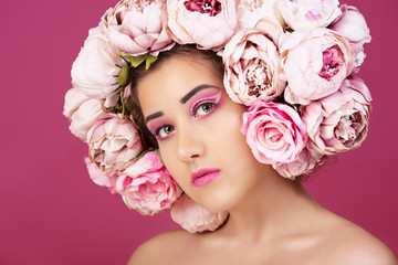 Close up portrait of beautiful young girl with pink roses flower on head and make up. Studio shot. Horizontal