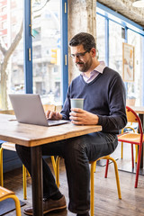 Middle aged businessman in a coffee shop with his computer