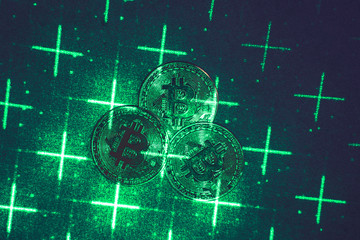 green laser beam and bitcoins in the dark