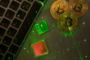 Laptop keyboard with bitcoins and green laser.