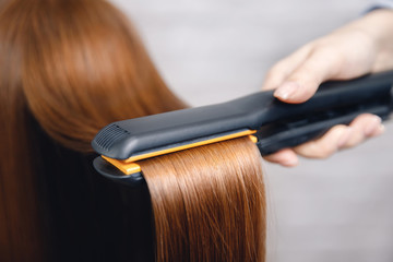 Hair straightening iron in beauty salon