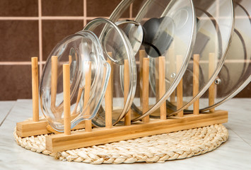 Wooden natural color rack for holding pot/pan lids in kitchen. Kitchen organizer interior element tool concept.