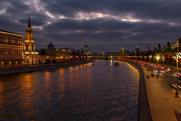 Fototapeta na wymiar Embankments of Moskva river against Moscow Kremlin on a background of cloudy sky at evening. City landscape