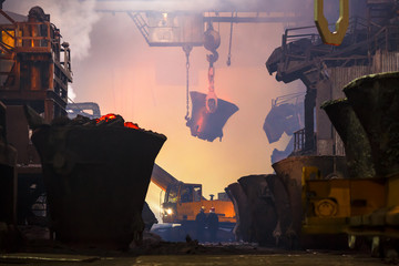 Copper production at the metallurgical plant. Large industrial structures, ore buckets, cranes and...