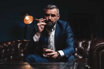 Attractive man with cigar and a glass whiskey