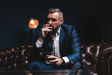 Attractive man with cigar and a glass whiskey