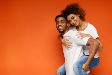 African-american couple having fun on orange background