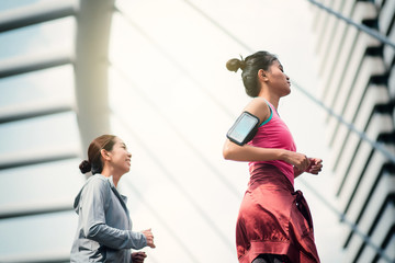 Two beautiful asian woman running in city. Sport Concept