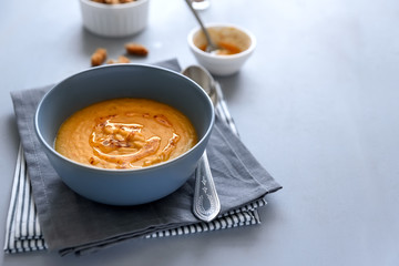 Bowl of red lentil soup on gray wooden background. Vegetarian food concept