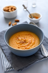 Bowl of red lentil soup on gray wooden background. Vegetarian food concept