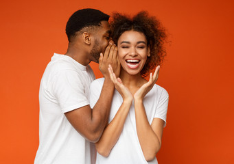 Naklejka premium Black man sharing secret with his girlfriend