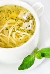 Bowl with chicken soup on white