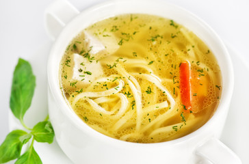 Bowl with chicken soup on white