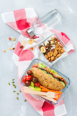 Lunch box with sandwich, fruits, vegetables, nut mix and water