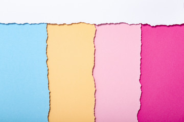 abstract background of multi-colored stripes of torn cardboard lying vertically, top view