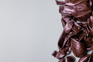 Pile of deflated burgundy balloons on a white background. Clean pure baloon template. Logo,...
