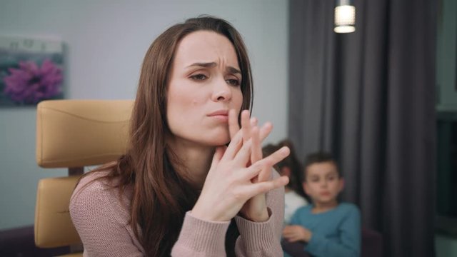 Unhappy mother working at home. Tired woman looking computer. Exhausted woman