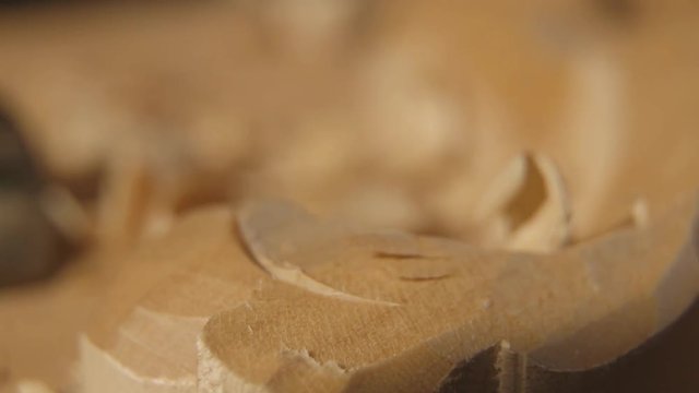 A man is wood carving a piece of classical furniture. Shot in Macro lens.