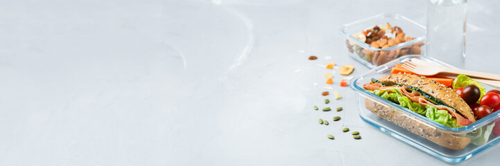 Lunch box with sandwich, fruits, vegetables, nut mix and water