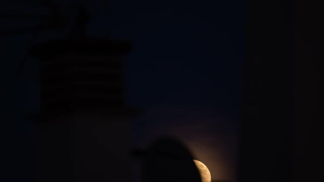 Full moon rising over rooftops