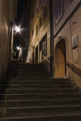Fototapeta na wymiar Stein Treppe mit Stufen an Haus mit Tür und Fenstern bei Nacht mit Strassenlampe und Licht