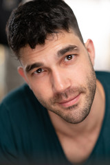 Fototapeta premium Handsome caucasian white male with black short hair and stubble with blue t shirt flirting