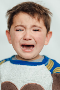 Baby crying in a studio - Image. Baby alone angry and crying. Petulant, peevish, Annoyed, Crying