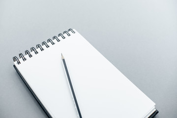  notepad  on a grey abstract background with copy space, minimal style. Flat lay blog mock-up. Top view of open spiral blank notebook. Several onbject top horizontal view.