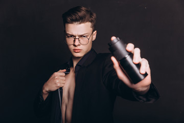 Handsome shirtless man putting deodorant. image of young man using deodorant isolated - Image. Handsome young man with deodorant on dark background - Image