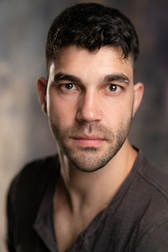 Handsome caucasian white male with black short hair and stubble with brown t shirt