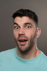 Fototapeta premium Handsome caucasian white male with black short hair and stubble with light blue t shirt