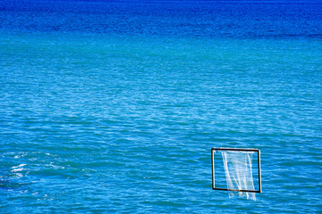 blue and turquoise sea, a water polo net on the right side