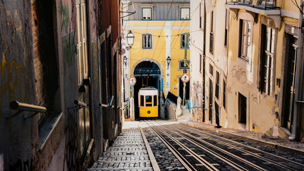  Romantic Lisbon street with the typical yellow tram in Lisbon city, Portugal on the background 
